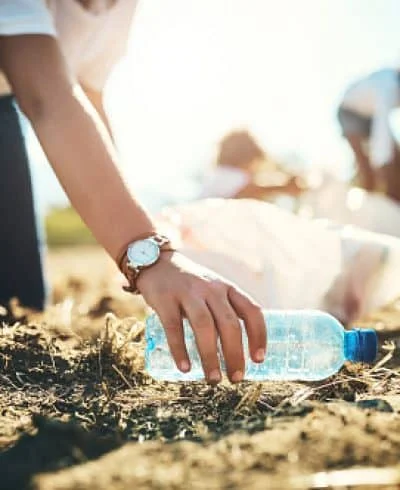 person taking a plastic bottle from the ground